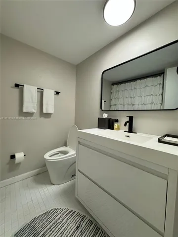 a bathroom with a toilet sink and mirror
