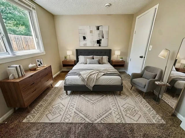 a spacious bedroom with a bed a couch and a window