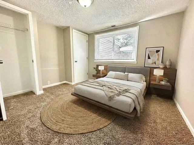 a bedroom with a bed and a painting on the wall