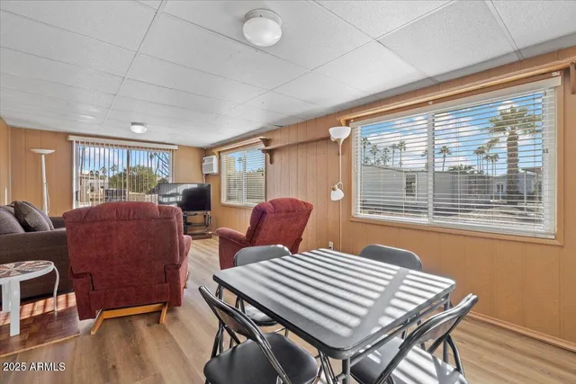 a living room with a couch and a dining table with wooden floor