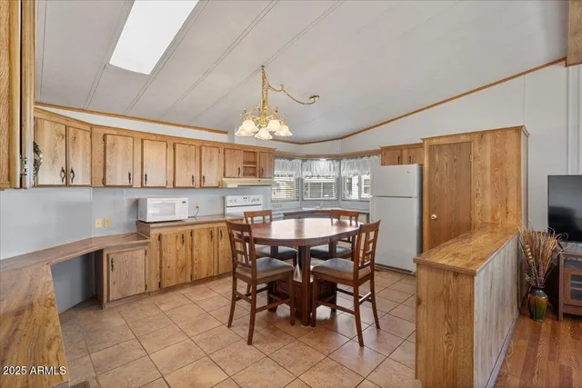 a kitchen with stainless steel appliances granite countertop a table chairs sink and cabinets