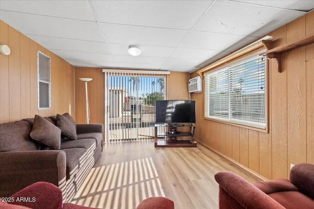 a living room with furniture a flat screen tv and a window