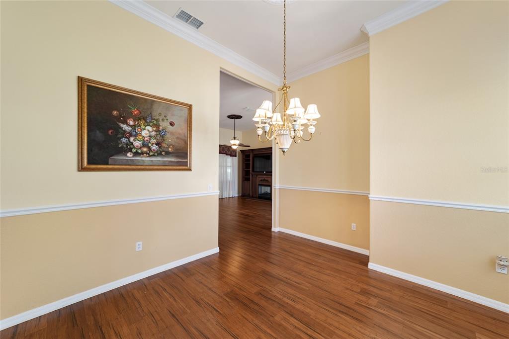 11017 Southwest 71st Terrace Road Ocala, FL 34476 - Photo 13 of 49 a view of a room with wooden floor and chandelier