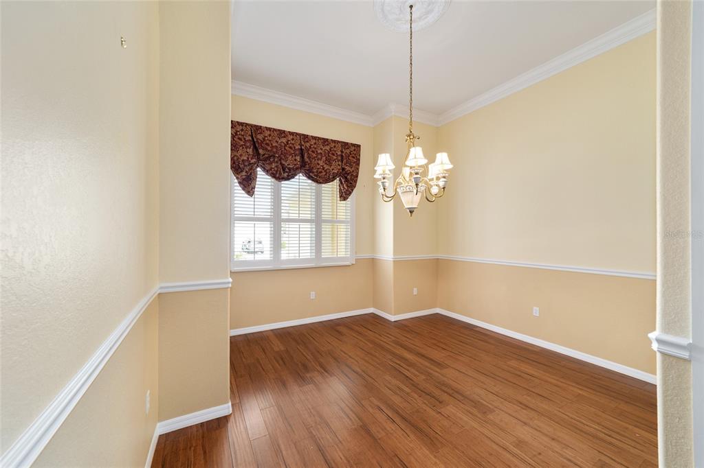 11017 Southwest 71st Terrace Road Ocala, FL 34476 - Photo 14 of 49 a view of a room with wooden floor and chandelier
