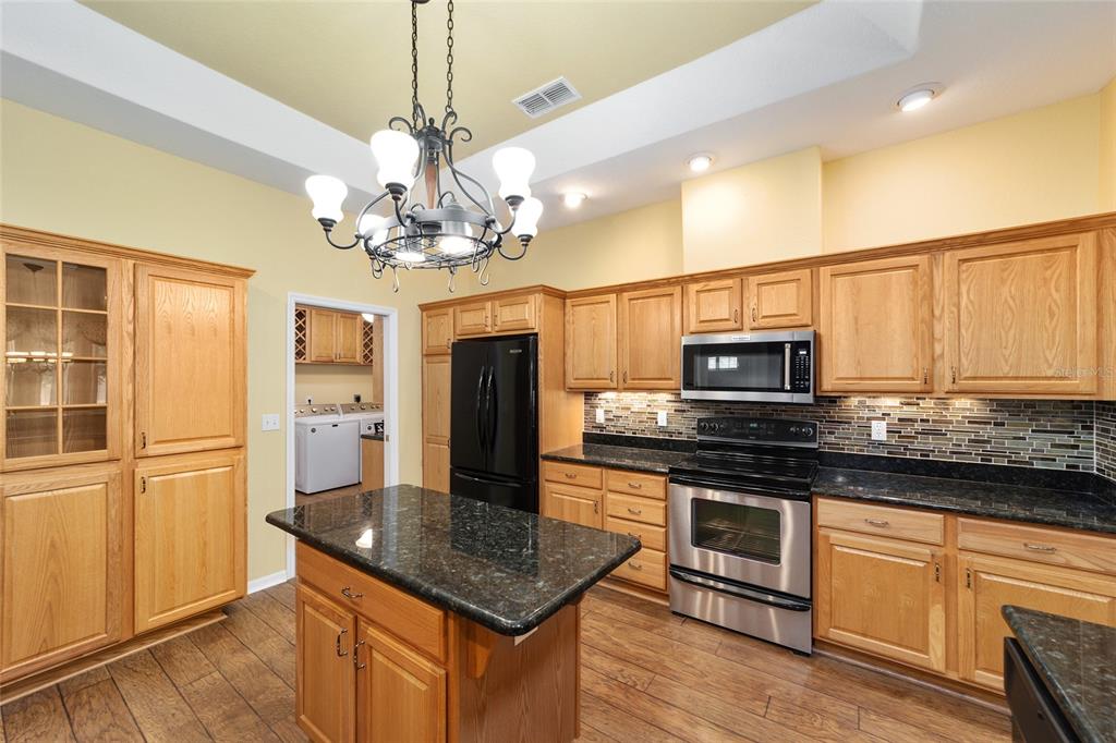 11017 Southwest 71st Terrace Road Ocala, FL 34476 - Photo 17 of 49 a kitchen with stainless steel appliances granite countertop a refrigerator a stove microwave and cabinets