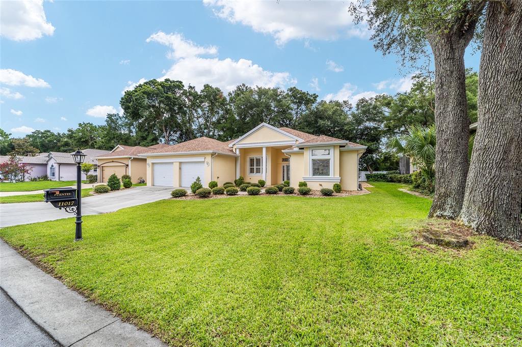 11017 Southwest 71st Terrace Road Ocala, FL 34476 - Photo 2 of 49 a yellow and house with a garden