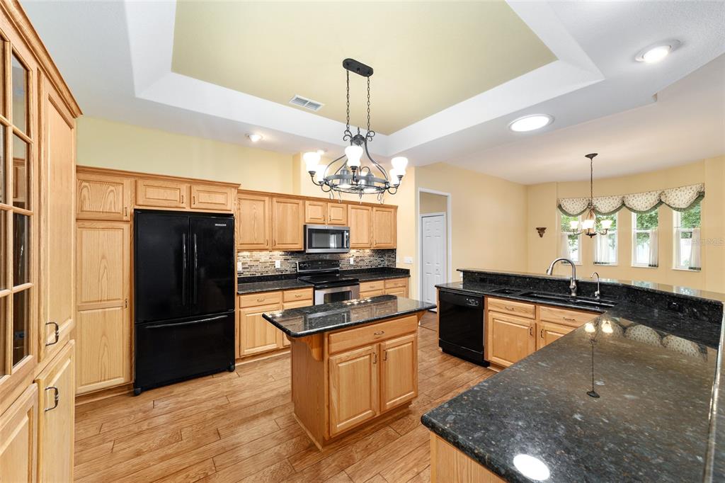 11017 Southwest 71st Terrace Road Ocala, FL 34476 - Photo 21 of 49 a kitchen with granite countertop stainless steel appliances and wooden floor