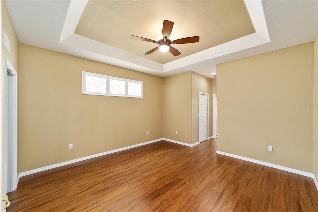11017 Southwest 71st Terrace Road Ocala, FL 34476 - Photo 23 of 49 a view of an empty room with wooden floor and a ceiling fan