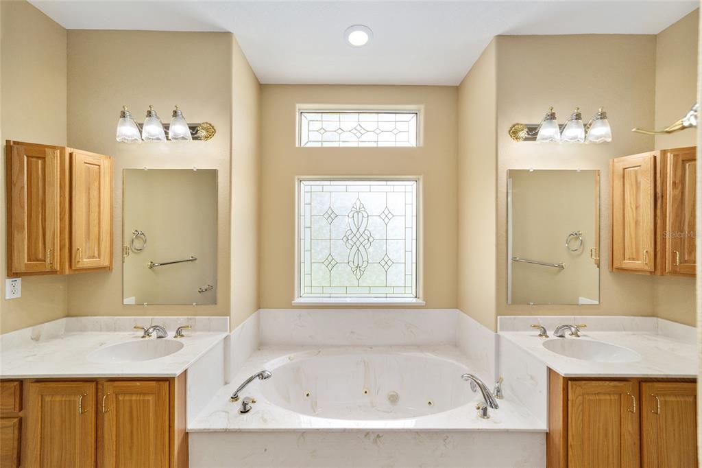 11017 Southwest 71st Terrace Road Ocala, FL 34476 - Photo 27 of 49 a bathroom with a tub sink and mirror