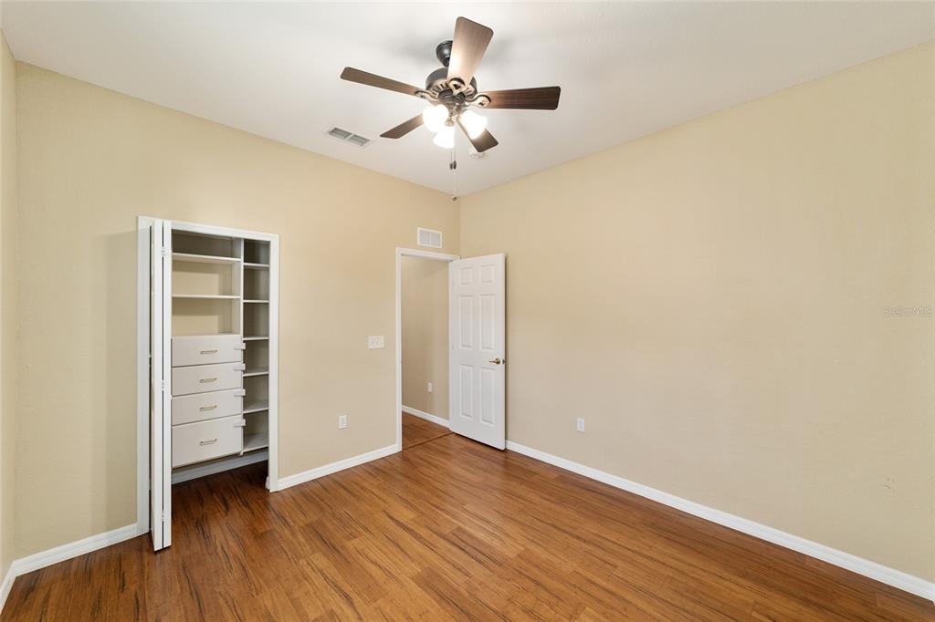 11017 Southwest 71st Terrace Road Ocala, FL 34476 - Photo 32 of 49 an empty room with wooden floor closet and windows