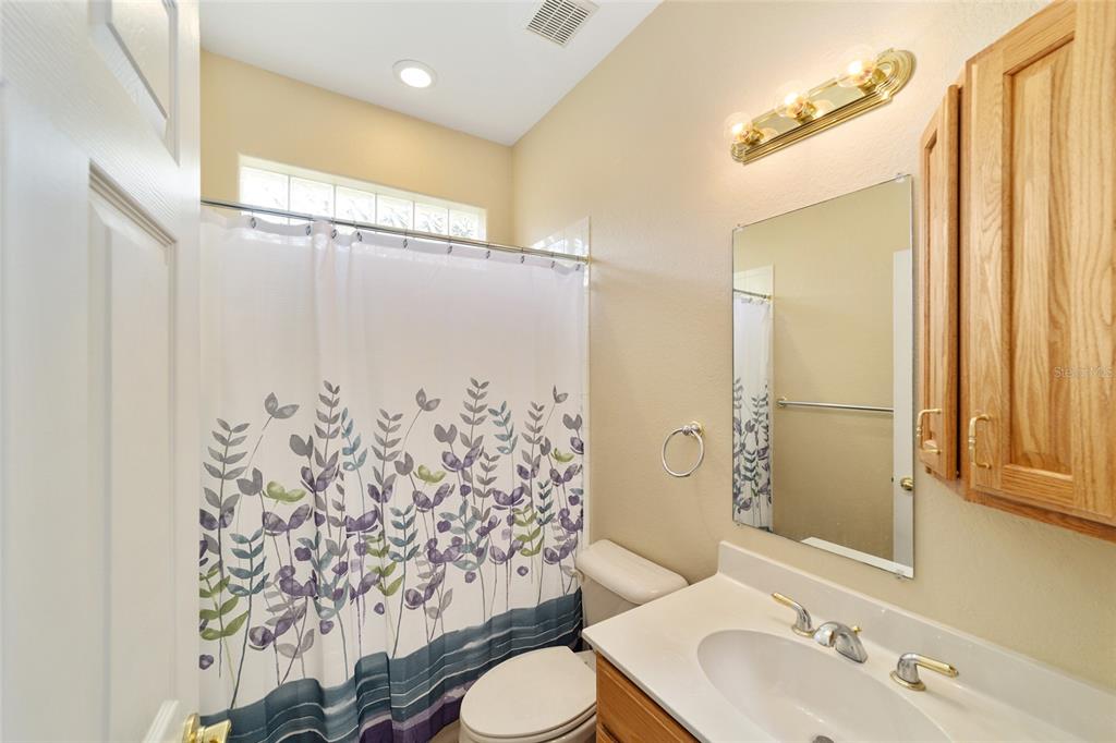 11017 Southwest 71st Terrace Road Ocala, FL 34476 - Photo 33 of 49 a bathroom with a shower curtain sink and a mirror