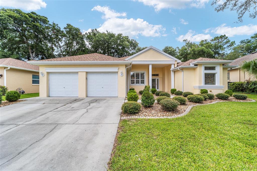 11017 Southwest 71st Terrace Road Ocala, FL 34476 - Photo 4 of 49 a front view of a house with a yard and potted plants