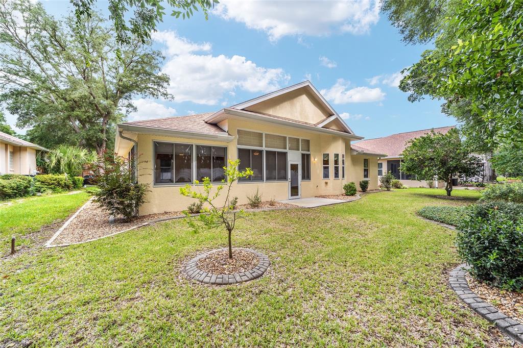 11017 Southwest 71st Terrace Road Ocala, FL 34476 - Photo 43 of 49 a front view of a house with a yard table and chairs