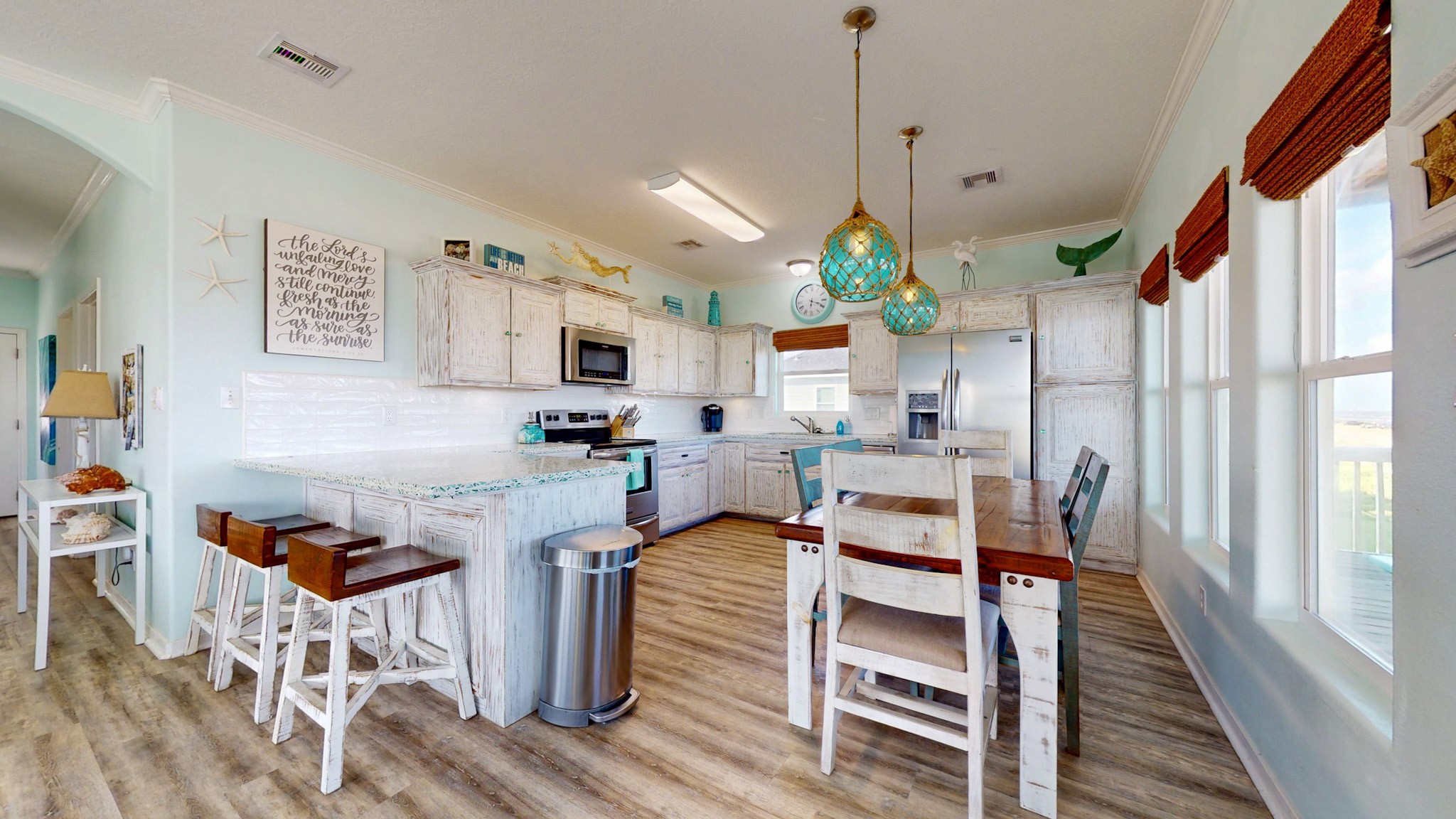 1822 Redfish Lane Crystal Beach, TX 77650 - Photo 9 of 28 a kitchen with stainless steel appliances kitchen island granite countertop a table chairs and a wooden floor