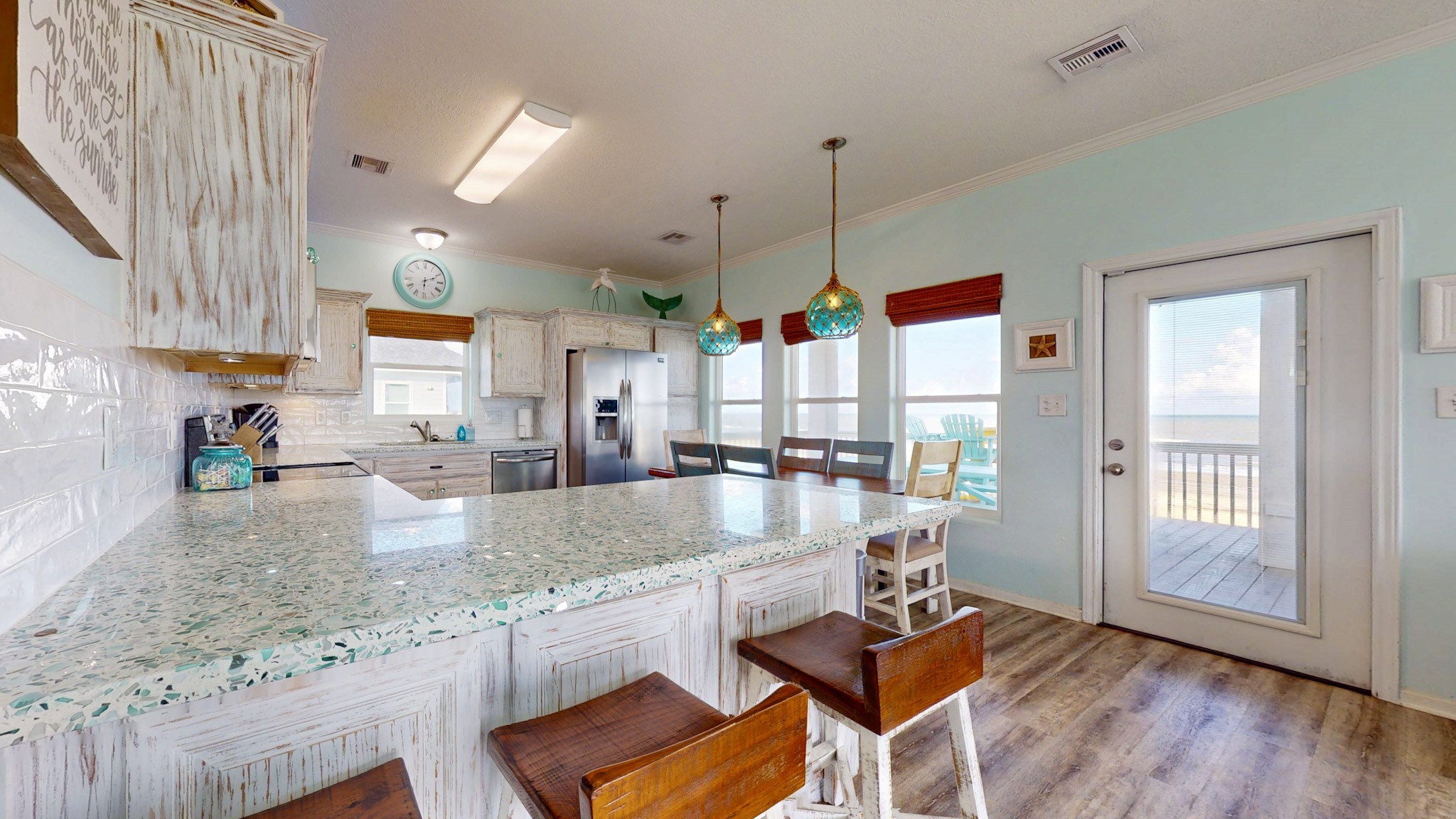 1822 Redfish Lane Crystal Beach, TX 77650 - Photo 10 of 28 a kitchen with granite countertop a stove and white cabinets with wooden floor