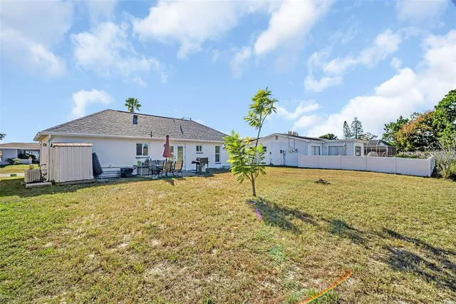 a view of a house with pool and chairs
