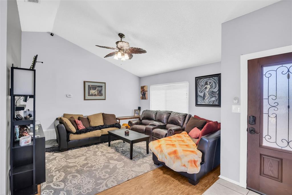 8425 Redfield Drive Port Richey, FL 34668 - Photo 3 of 13 a living room with furniture ceiling fan and a rug