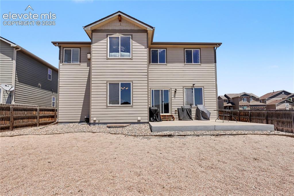 6598 Alliance Loop Colorado Springs, CO 80925 - Photo 37 of 39 Rear exterior with light beige siding and white trim