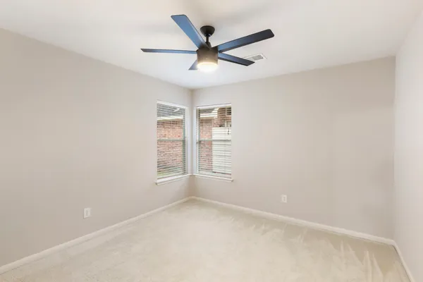 a view of a room with a chandelier fan and a window
