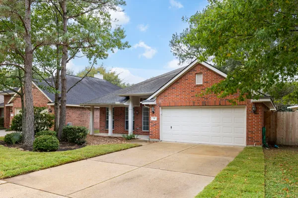 a front view of house with yard and trees in the background