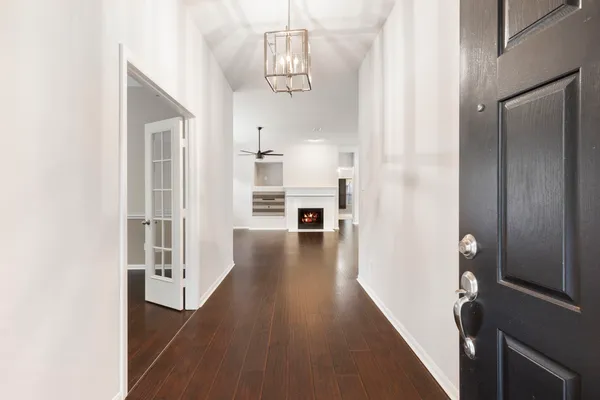 a view of a hallway with wooden floor and staircase