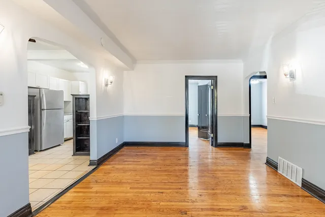 a view of empty room with wooden floor