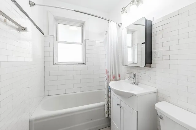 a white bath tub sitting next to a white sink and a toilet