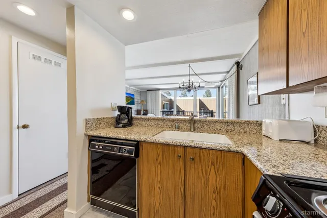 a kitchen with granite countertop a sink stainless steel appliances and cabinets