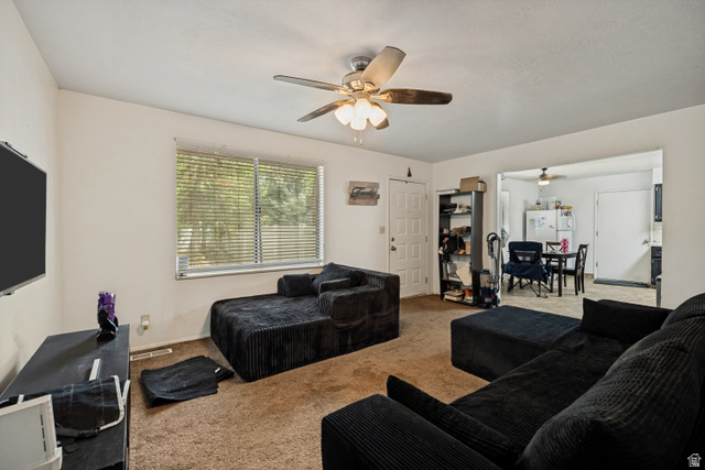 6709 Acoma Road, Unit 239 Midvale, UT 84047 - Photo 26 of 38 6709 - Main level living room. Carpeted living area with a ceiling fan, a window with horizontal blinds, and a doorway opening to an additional room