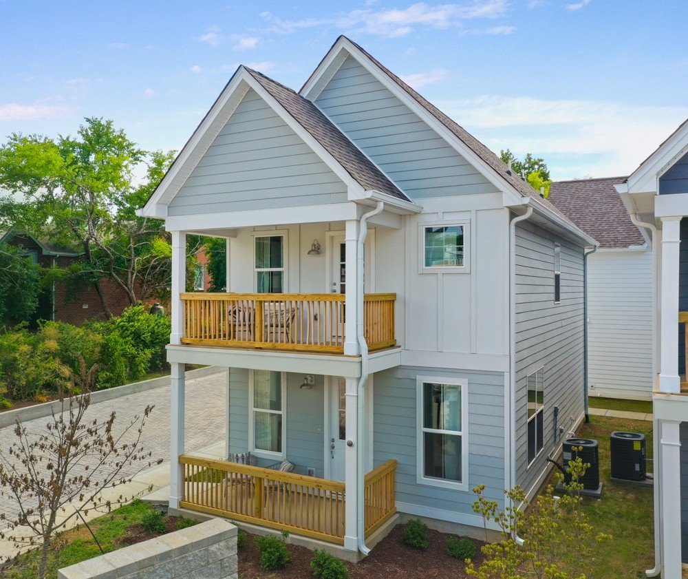 a view of house with yard and sitting area