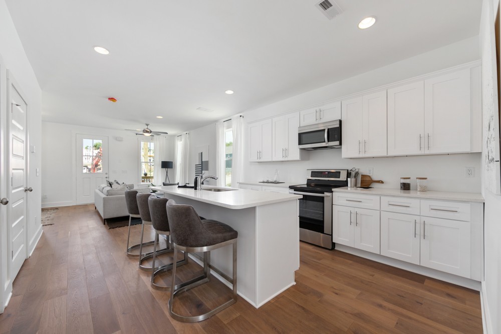 422 Creative Way Madison, TN 37115 - Photo 7 of 42 a kitchen with white cabinets stainless steel appliances and dining table