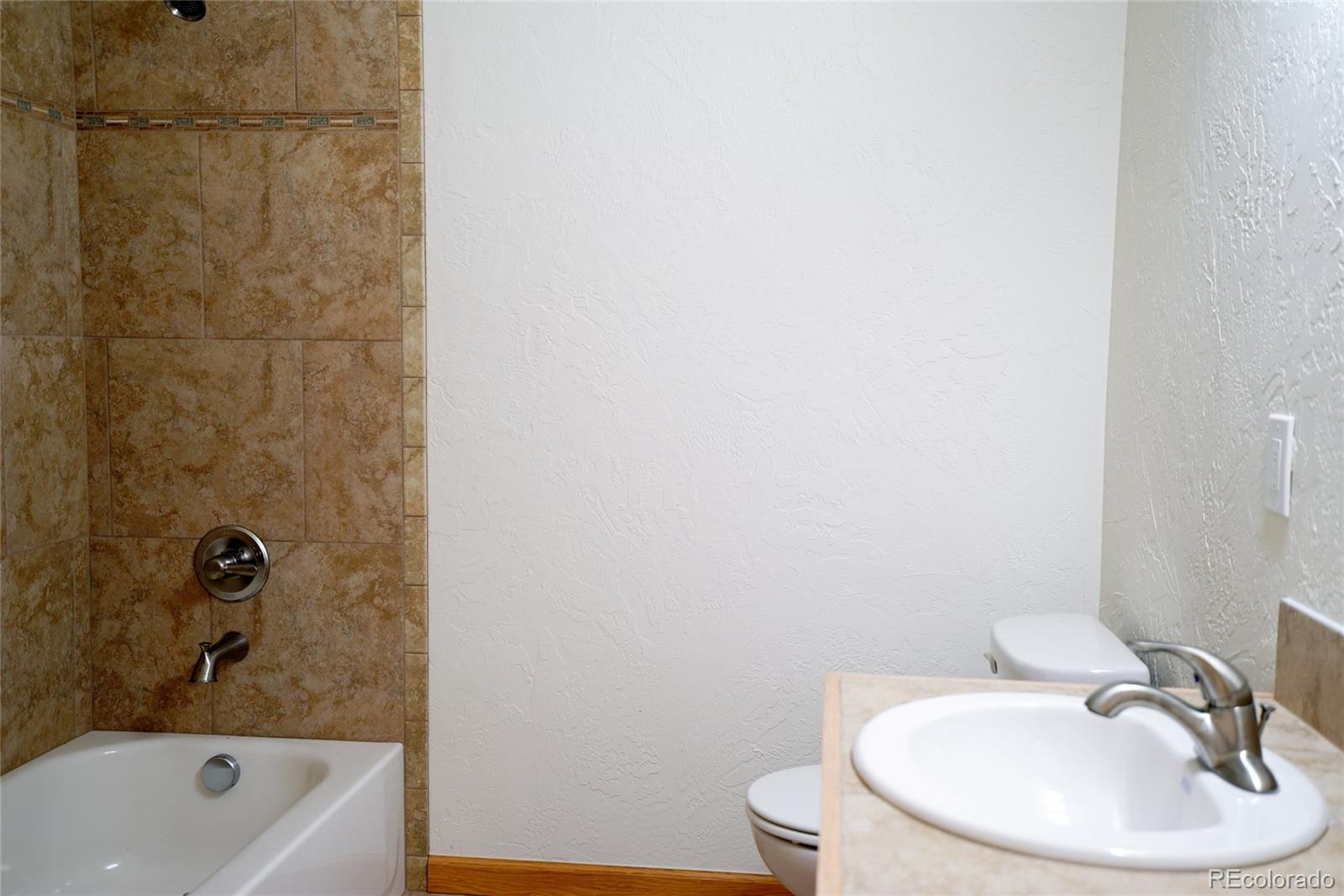 311 Quartz Circle Bailey, CO 80421 - Photo 27 of 30 a bathroom with a sink a toilet and shower