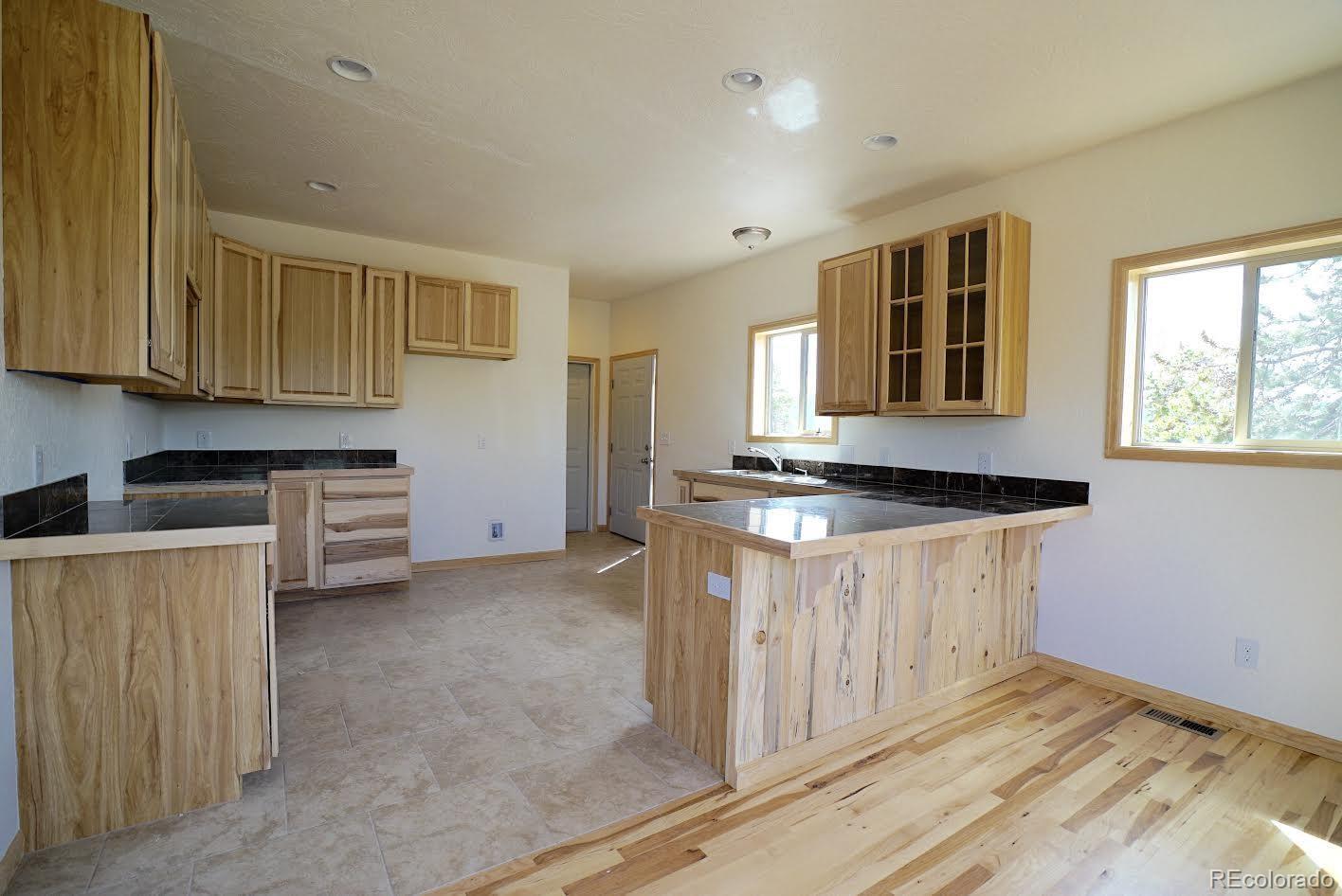 311 Quartz Circle Bailey, CO 80421 - Photo 6 of 30 a kitchen with granite countertop a sink stove and cabinets