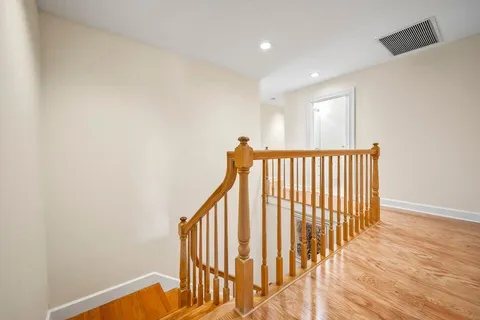 a view of a hallway with wooden floor and staircase