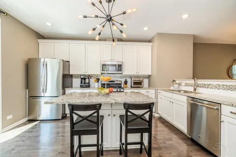 a kitchen with a refrigerator a stove a sink and cabinets