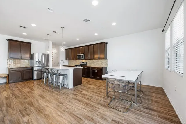 a kitchen with stainless steel appliances granite countertop a stove and a wooden floors