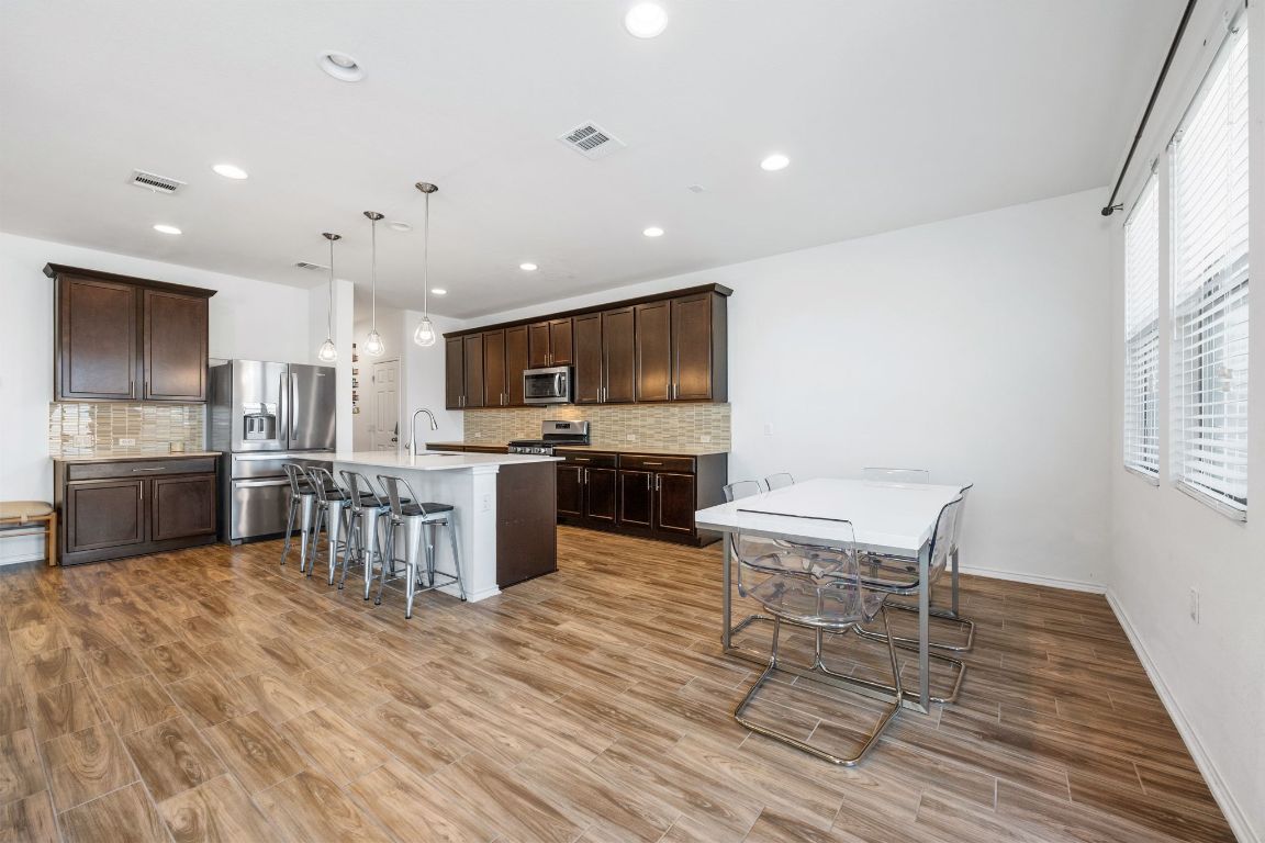 1902 Tasmanian Tiger Trace Austin, TX 78728 - Photo 11 of 29 a kitchen with stainless steel appliances kitchen island granite countertop a sink cabinets and wooden floor