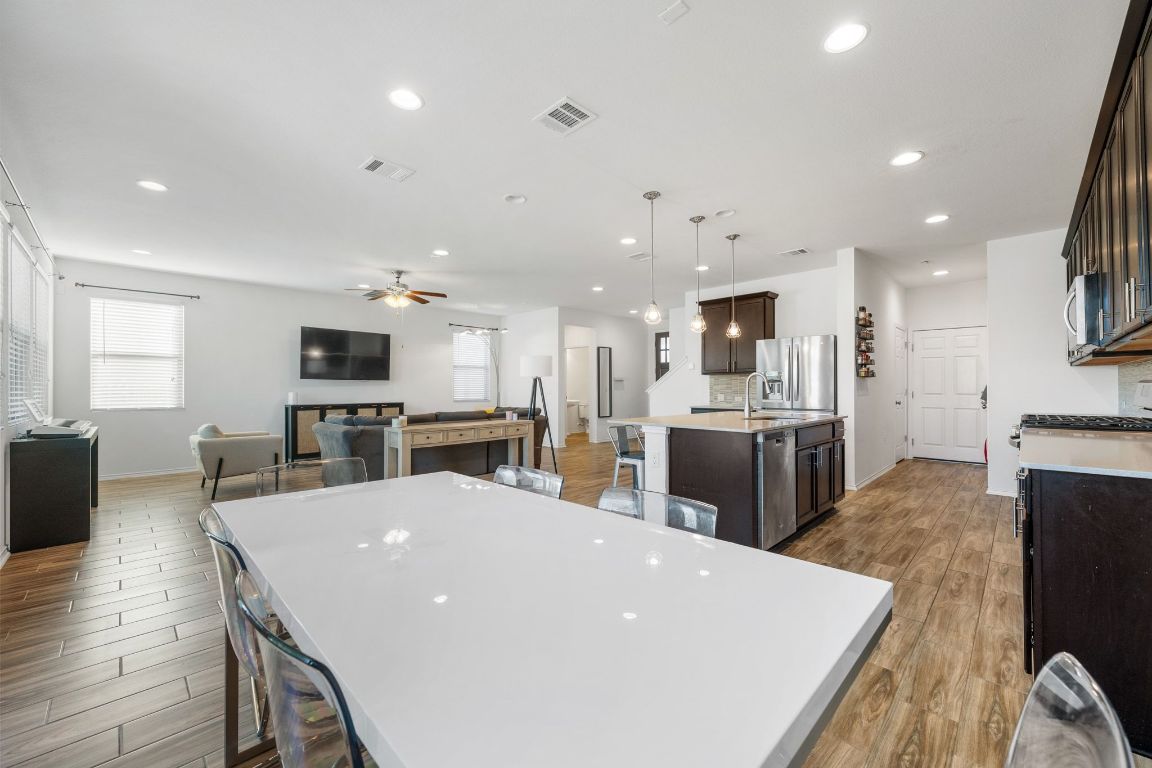 1902 Tasmanian Tiger Trace Austin, TX 78728 - Photo 28 of 29 a large kitchen with kitchen island a stove a sink a dining table and chairs
