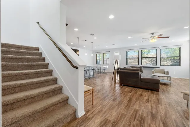 a kitchen with stainless steel appliances kitchen island granite countertop a sink cabinets and wooden floor