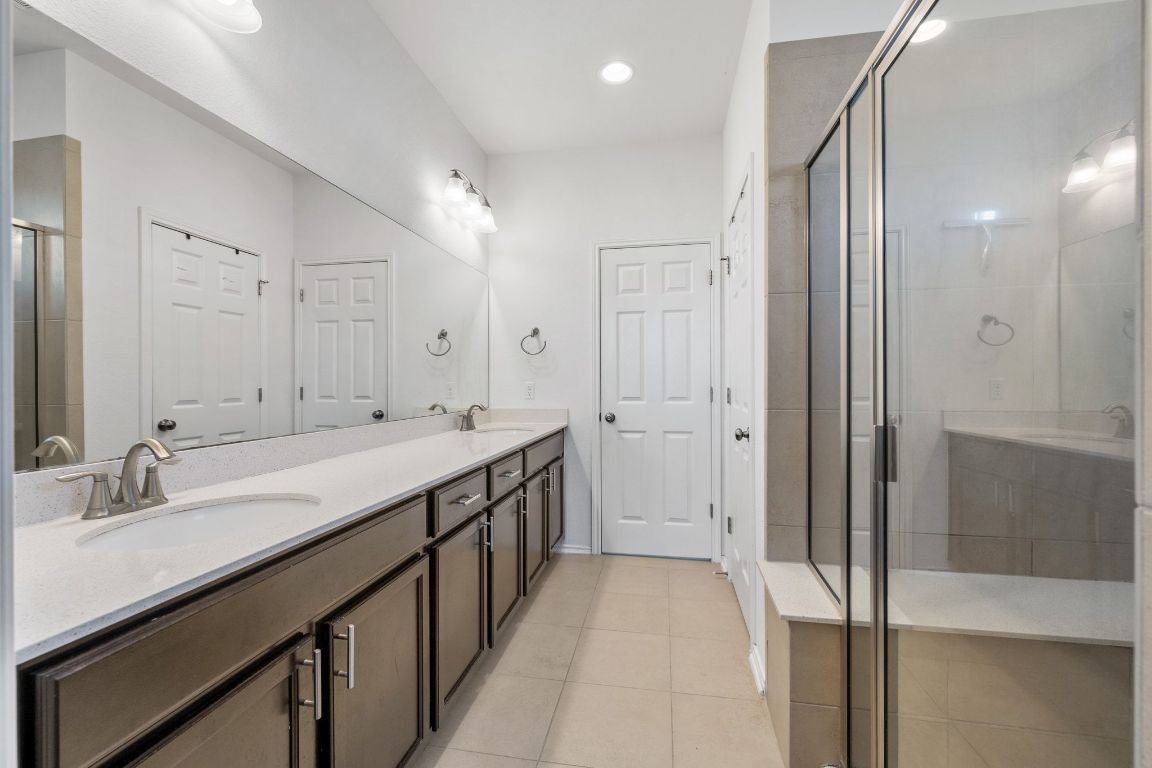 1902 Tasmanian Tiger Trace Austin, TX 78728 - Photo 16 of 29 a spacious bathroom with a double vanity sink a large mirror and shower