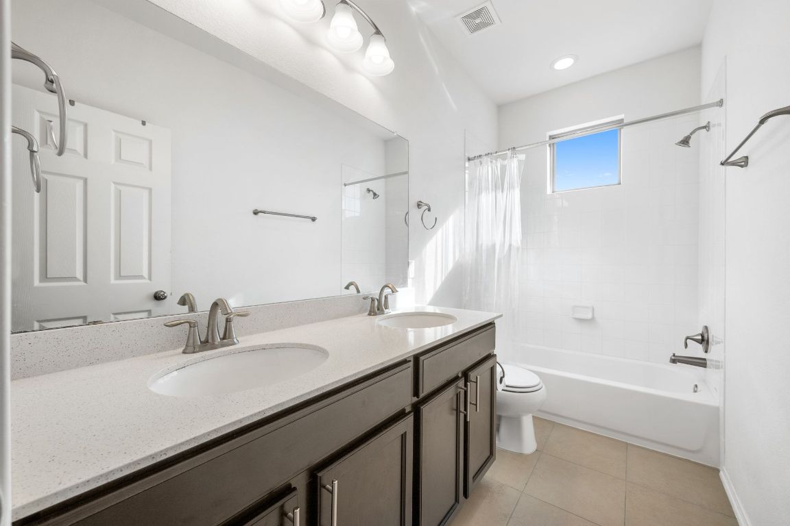1902 Tasmanian Tiger Trace Austin, TX 78728 - Photo 18 of 29 a bathroom with a granite countertop sink a toilet and shower
