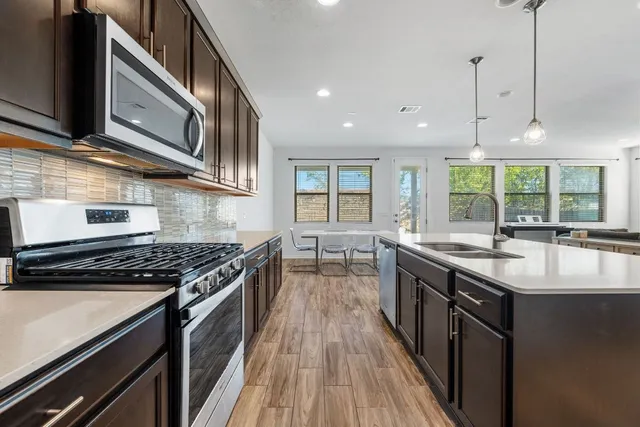 a kitchen with stainless steel appliances granite countertop a stove and a sink