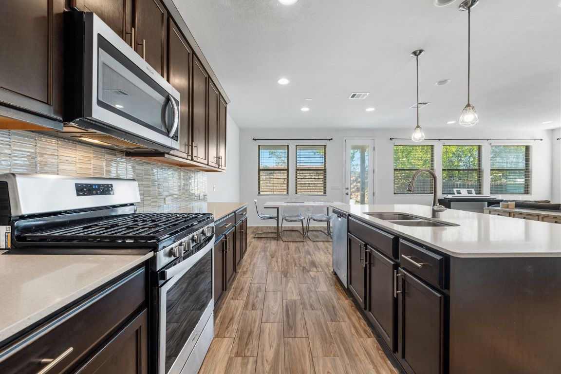 1902 Tasmanian Tiger Trace Austin, TX 78728 - Photo 10 of 29 a kitchen with stainless steel appliances granite countertop a stove and a sink