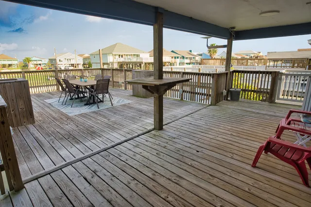 a view of a roof deck with table and chairs barbeque with wooden floor
