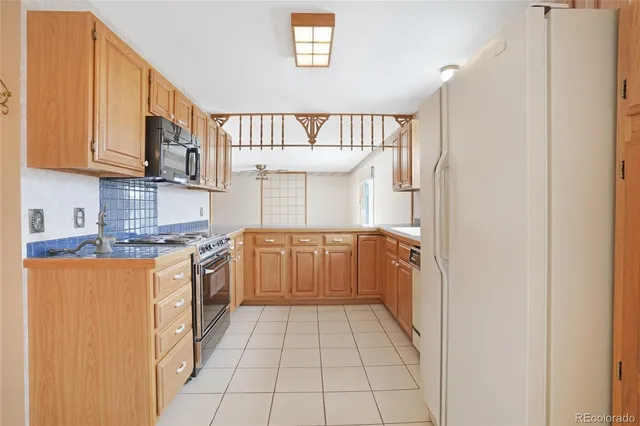 a kitchen with stainless steel appliances granite countertop a sink and a refrigerator