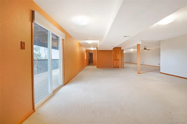 a view of an empty room with closet and a window