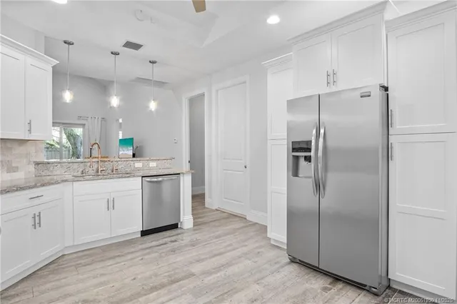 a kitchen with a refrigerator sink and cabinets