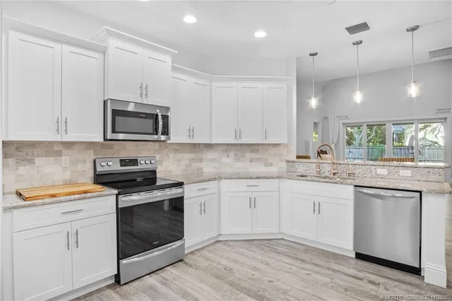 a kitchen with granite countertop white cabinets and white appliances