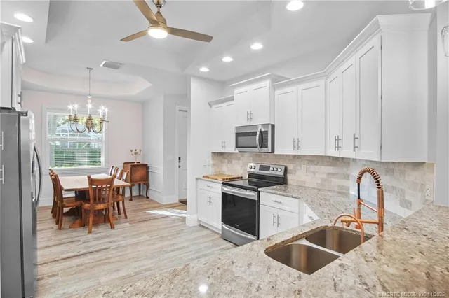 a kitchen with stainless steel appliances granite countertop a sink stove and refrigerator