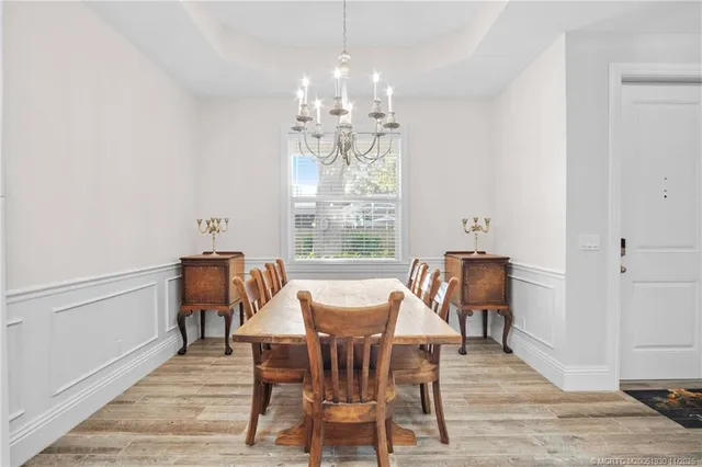 a view of a dining room with furniture a chandelier and wooden floor